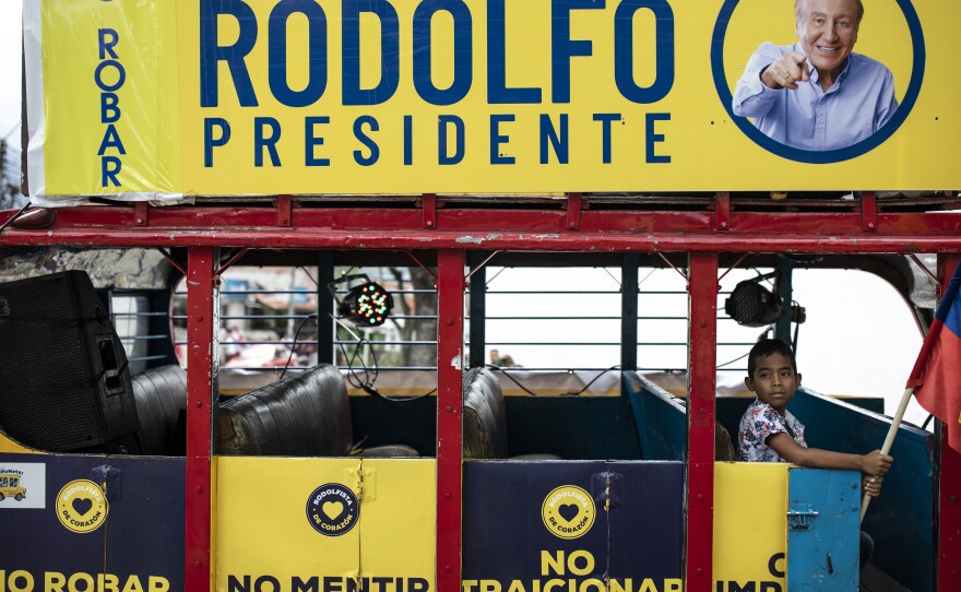 A child sits in the "Rodolfoneta" holding a national flag during a caravan showing support for presidential candidate Rodolfo Hernandez a day ahead of the country's presidential run-off, in Bucaramanga, Colombia, Saturday, June 18, 2022.