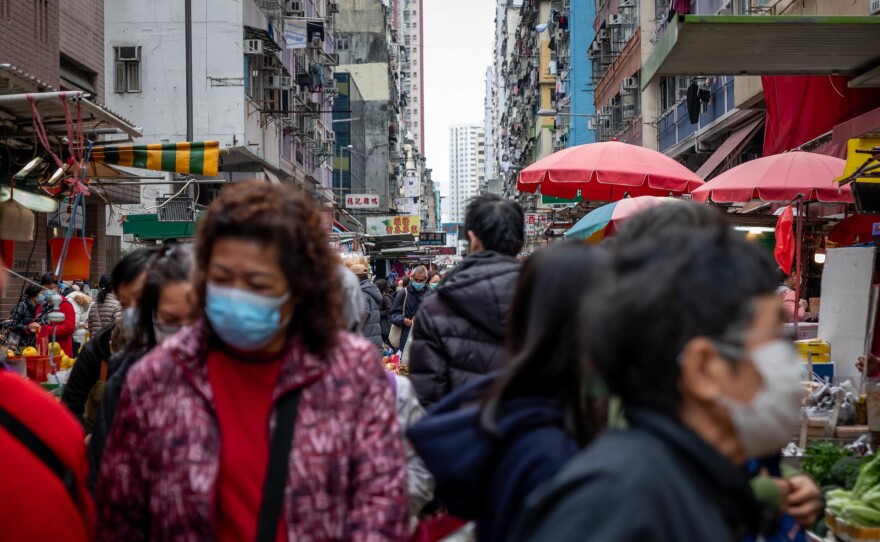 People shop in a Hong Kong market for fruits and vegetables. In this city of more than 7 million, many people have had their businesses or lives disrupted by the viral outbreak.