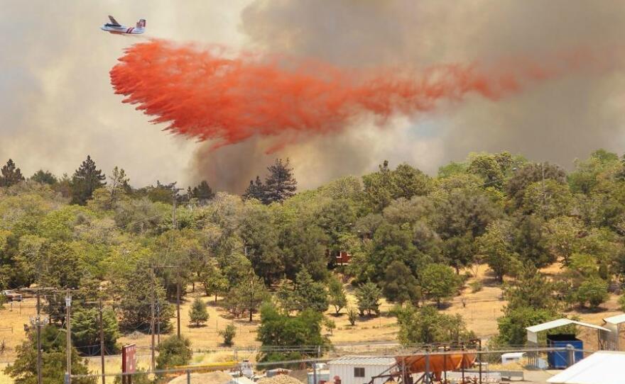 An air tanker drops fire retardant on a brush fire near Julian, July 3, 2014.