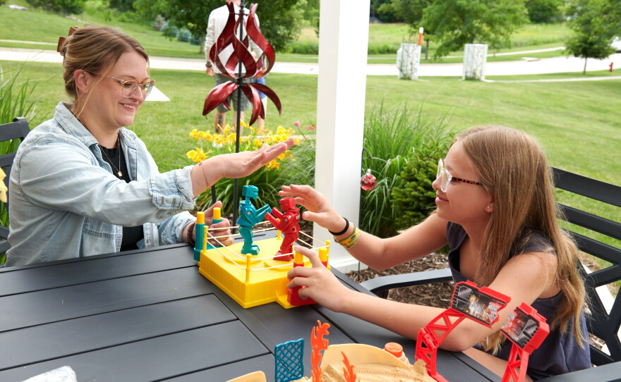 Amber Petersen and Piper, 12, play together on a patio. Amber wishes she could spend more time with her children, but the family needs two incomes.