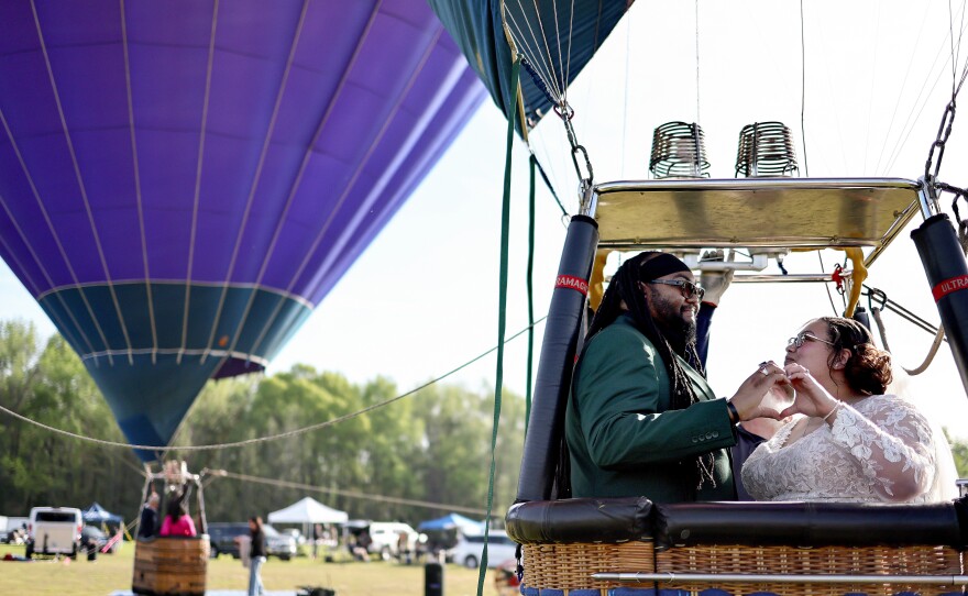 Bride and groom Kylee and Michael Rice prepare to take a hot air balloon ride before a planned mass wedding of over 200 couples at the Total Eclipse of the Heart festival in Russellville, Ark.