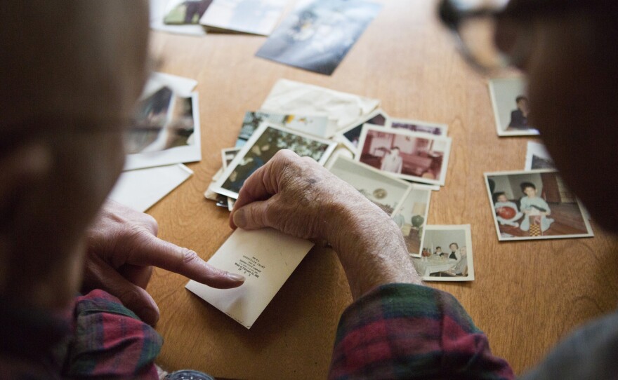 Stanley looks at old photographs with his sons. He's 91 now, but his voice sounds nearly the same as it did on the tape.