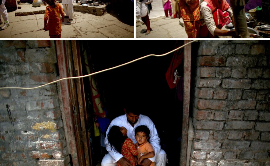 Akhtar Ali, 44, with two of his 10 children, lives with his family along the floodplain of the Yamuna River. Land is available there — Ali bought his — but the settlement he lives in is not authorized by the government. When the river floods, he's forced to move the family to higher ground.