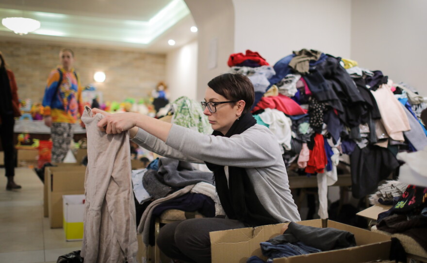 A volunteer at the hotel sorts donated clothing.