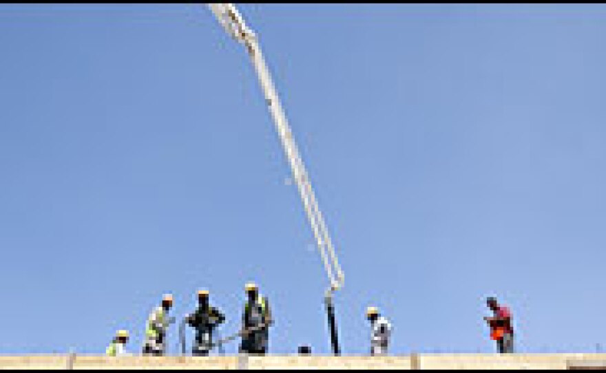 Workers pour a slab of concrete for one of the new structures. More than $780 million will be spent on permanent infrastructure for the NATO base.