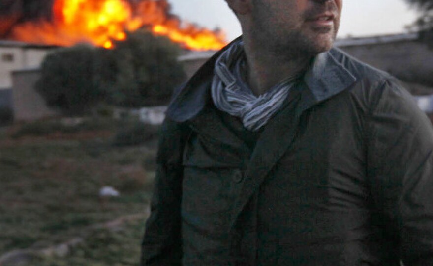Chris Hondros stands in front of a burning building in Misrata, Libya, on April 18. Hondros, 41, died April 20, after being seriously wounded while on assignment in Misrata.