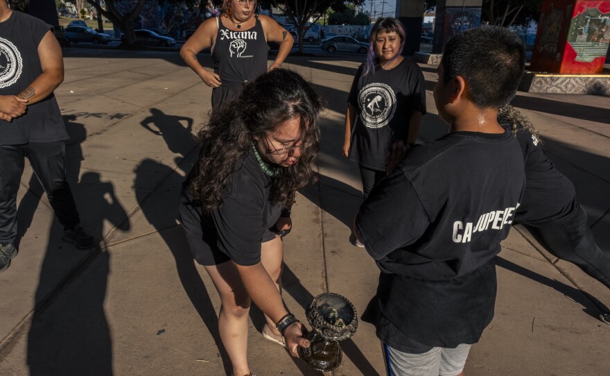 Veronica Mendez performs the smudging ritual for her teammates at Chicano Park on Friday, July 21, 2023.