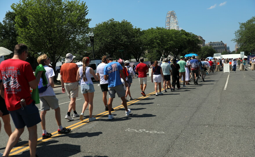 Attendees walk to attend Independence Day events honoring the nation's 250th anniversary, Saturday, July 4, 2026, on the National Mall in Washington.