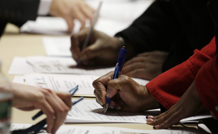 Applicants complete forms at a job fair in Newark, N.J. Weak U.S. job growth comes at the same time benefits for the long-term unemployed are shrinking.