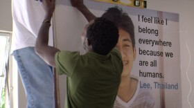 Sedrick Ntwali, a San Diego refugee from Congo, helps put the finishing touches on a World Refugee Day display at the Bridge of Hope Community Center in City Heights.