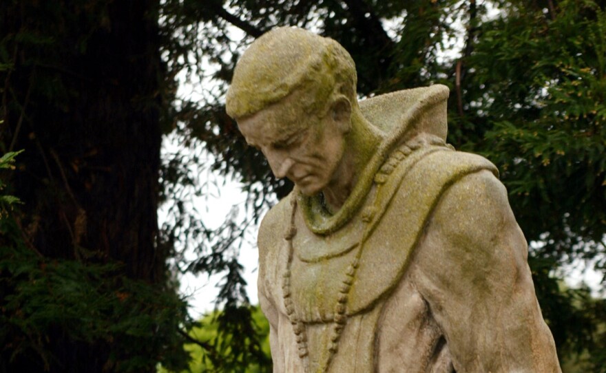 A statue of Father Junipero Serra stands in the cemetery of the historic Mission Dolores in San Francisco.