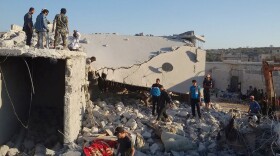 This photo was provided by an anti-Bashar Assad activist group, Edlib News Network (ENN), and authenticated based on its contents and other AP reporting. According to ENN it shows Syrian citizens checking a damaged house that was targeted by the coalition airstrikes, in the village of Kfar Derian, a base for the al-Qaida-linked Nusra Front, a rival of the Islamic State group, between the northern province of Aleppo and Idlib, Syria, Sept. 23, 2014. 