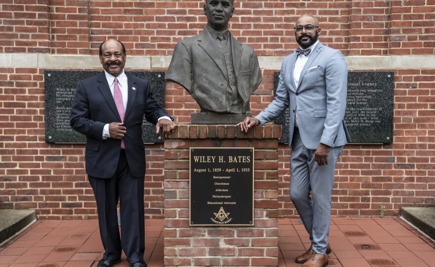 Carl Snowden (left) and attorney Daryl Jones (right), stand next to the Wiley H. Bates bust. Bates was born an enslaved man and rose to become a businessman and civic leader in Annapolis, Md.