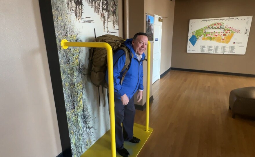 KPBS reporter John Carroll is shown trying out the marine backpack at MCRD Command Museum on January 29, 2025.