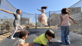 Palestinian children leap into the air while playing on a trampoline in northern Gaza's militarized orange zone of Beit Lahia, on May 31.