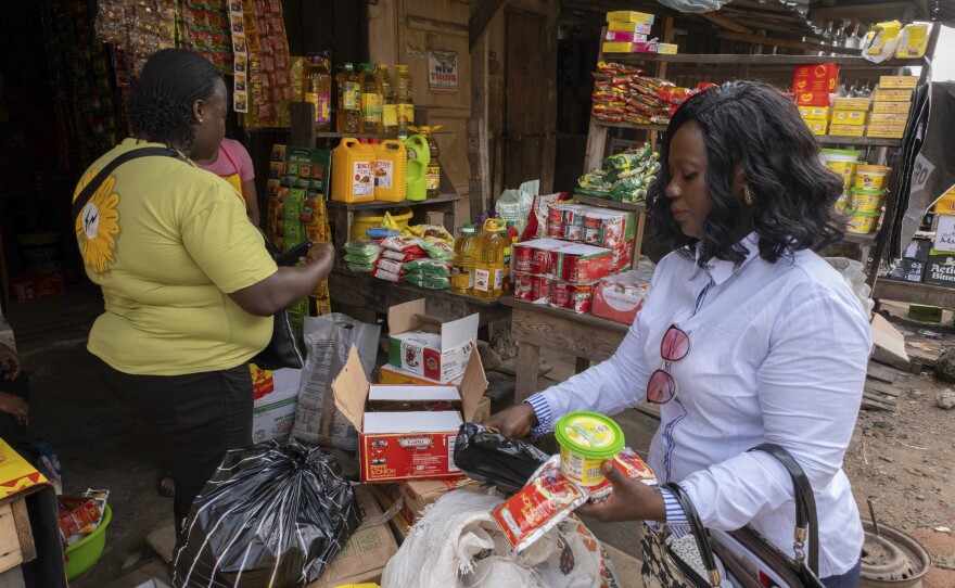 Food prices have risen dramatically since the start of the pandemic. Above: Edith Obatuga (right), who is bringing up her two children and four nieces and nephews, shops at a market in Lagos, Nigeria.