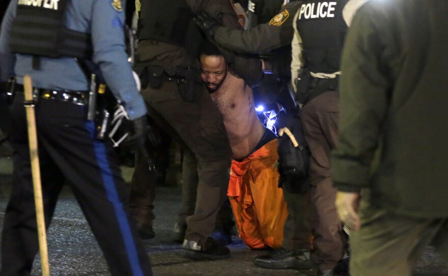 A man is arrested by police after kneeling in the street during a protest outside the Ferguson Police Department on Saturday.
