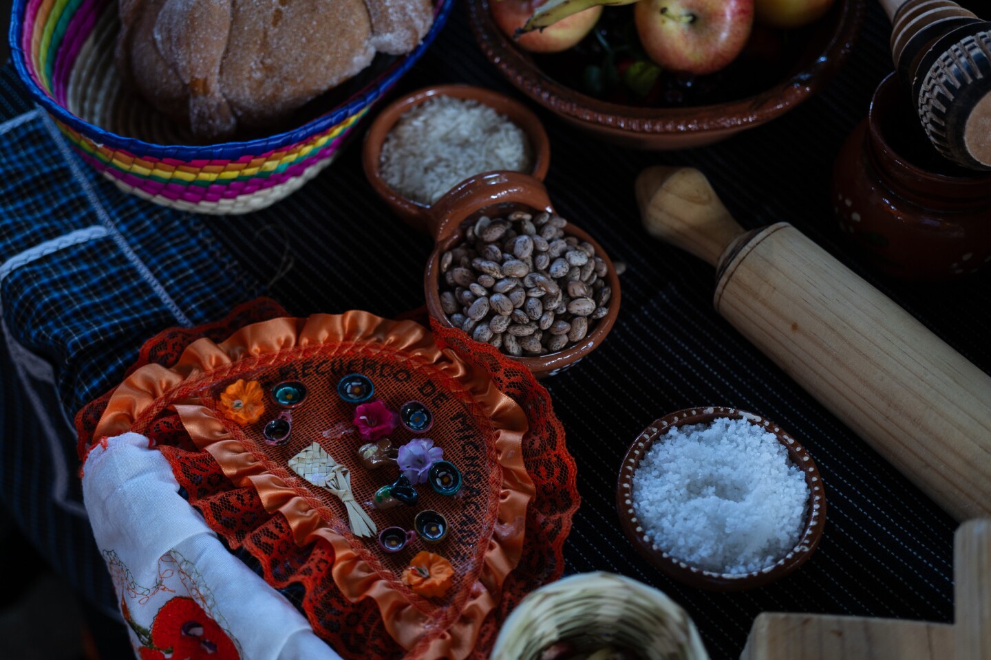 Dried beans, rice, salt and pan de muerto sit on an altar at the Sherman Heights Community Center in San Diego on Oct. 17, 2023. It is believed that placing a lost loved one's favorite foods on the altar helps guide their spirits back from the dead.