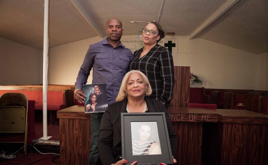 Karim Saafir (holding photo of Kenitha Saafir), Nikki High, and Patricia Strong-Fargas (sitting) with a photo of Kristin High.