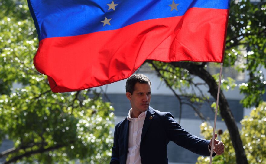 Venezuelan opposition leader Juan Guaidó is pictured under a national flag during a gathering with supporters on April 30, 2019. Delegates for both Guaidó and Nicolás Maduro are slated to hold direct talks in Norway this week aimed at ending the crisis in Venezuela.