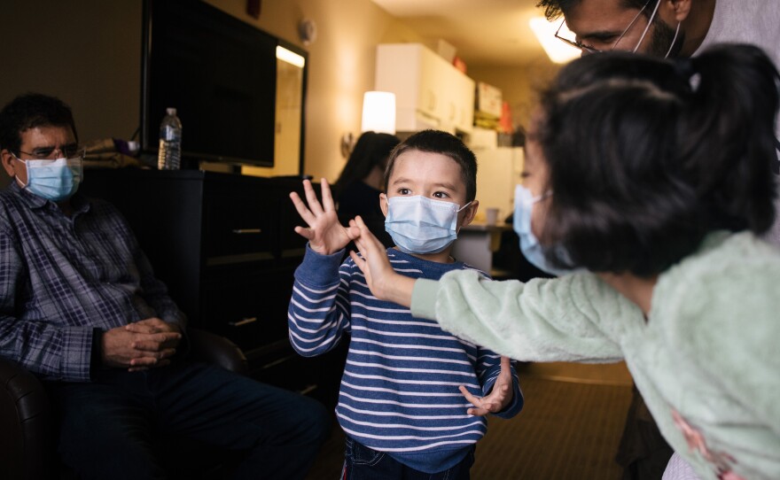 Kamila Noori's grandson Abaseen, 4, shares how old he is with help from his sister Leema, 7, in their grandparents' hotel room in Vienna, Va.