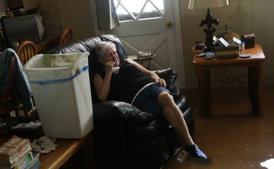 Elsie Lazarus is overcome with emotion Thursday as she sits in her flooded living room while retrieving what she can from her home in St. Amant, La.