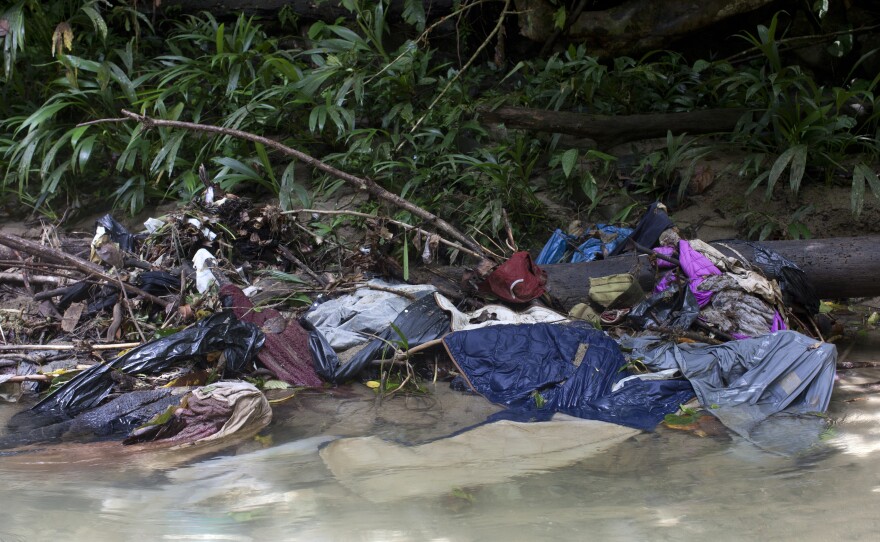 Clothes and garbage discarded on the side of the Acandiseco river in the Darién jungle, Colombia.