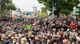Thousands gather in Hillcrest near the Pride Flag after marching from the Waterfront Park by San Diego Bay to protest the police killing of George Floyd and other black men and women, June 6, 2020. The group later returned to the park.