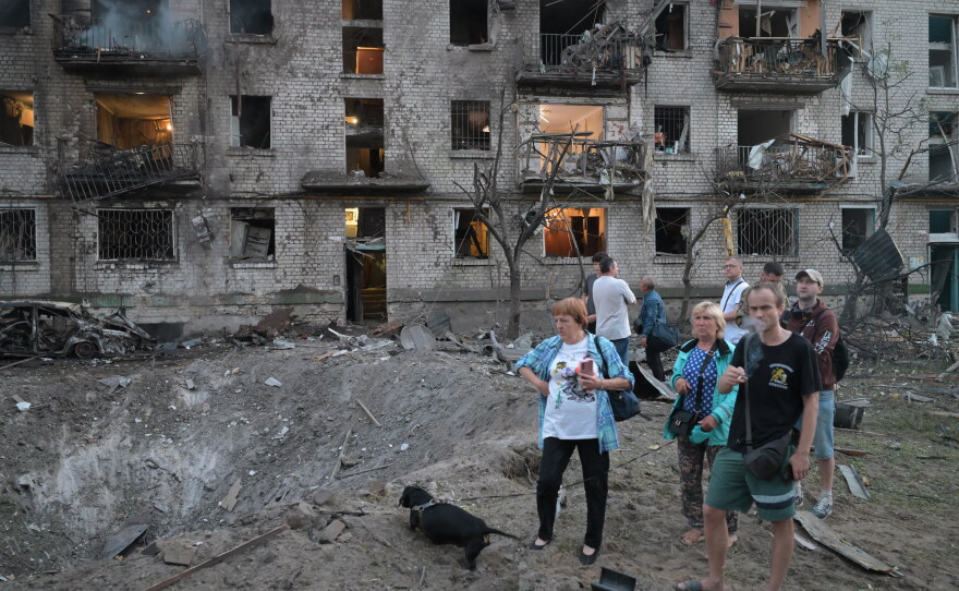 People look at the site of a Russian missile strike that hit a residential building in Kyiv, Ukraine, Thursday, July 2, 2026.