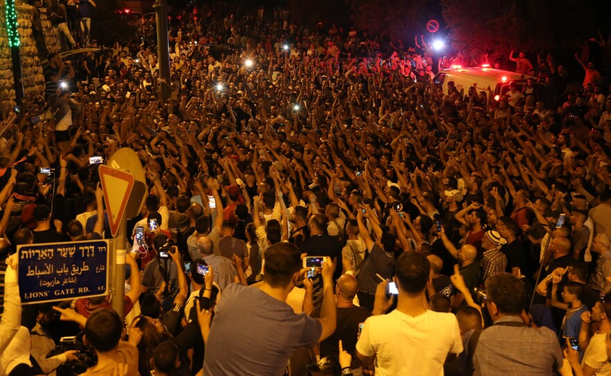 Palestinians celebrate in front of the Lion's Gate entrance to Al-Aqsa Mosque after Israeli security measures were removed from the Al-Aqsa Compound in Jerusalem on Wednesday.
