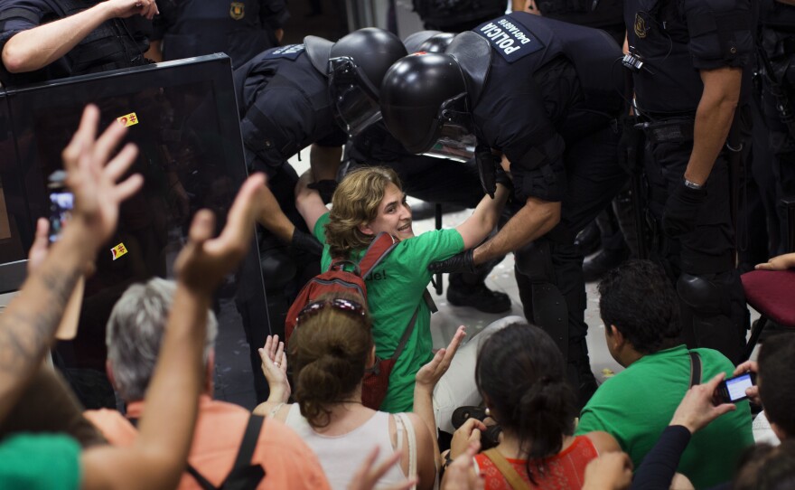 Ada Colau was carried out by riot police officers after occupying a bank in Barcelona in July 2013. Two years later, she was elected the city's mayor.