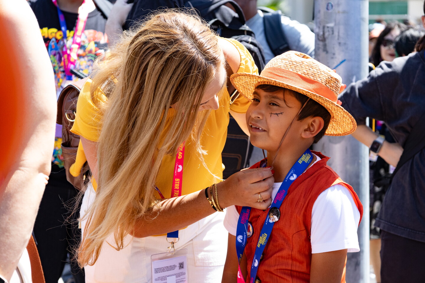 A mother adjusts her boy's costume while in line outside of Comic-Con, April 23, 2026.