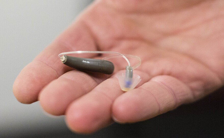 The FDA is moving to approve OTC hearing aids, in a change that lawmakers and advocates have long called for. Here, a man displays his hearing aid before taking part in a meeting.