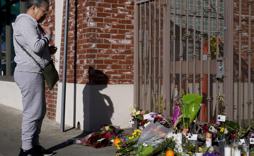 Ten people were killed and 10 more were injured at a dance studio near a Lunar New Year celebration on Saturday night. Here, a woman is seen praying for victims outside Star Dance Studio in Monterey Park, Calif., on Monday.