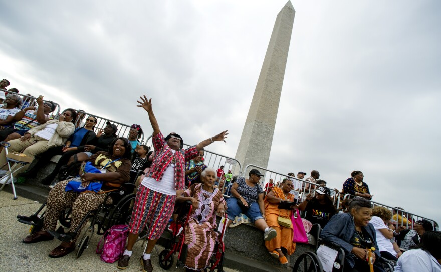 Ida Mae Hughes, 86, of Kansas City, Mo., raises her hands as President Barack Obama arrives at the dedication and opening ceremony of the Smithsonian's National Museum of African American History and Culture.