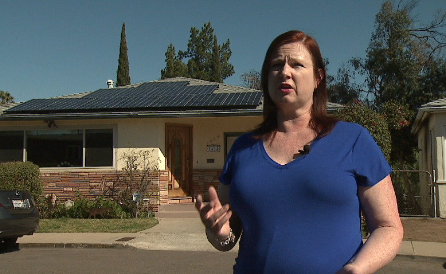 San Diego homeowner Finella Arnold talks about her solar-equipped house in the background, Jan. 25, 2016. 