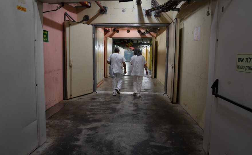 Hospital employees walk underground in a hallway at Galilee Medical Center, a community hospital in Nahariya, in northern Israel.