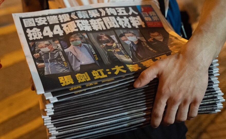 A man buys multiple copies of the latest Apple Daily newspaper in Hong Kong. Police raided the office of Apple Daily, the city's fierce pro-democracy newspaper, in an operation involving more than 200 officers. Secretary for Security John Lee said the company used "news coverage as a tool" to harm national security, according to local media reports.