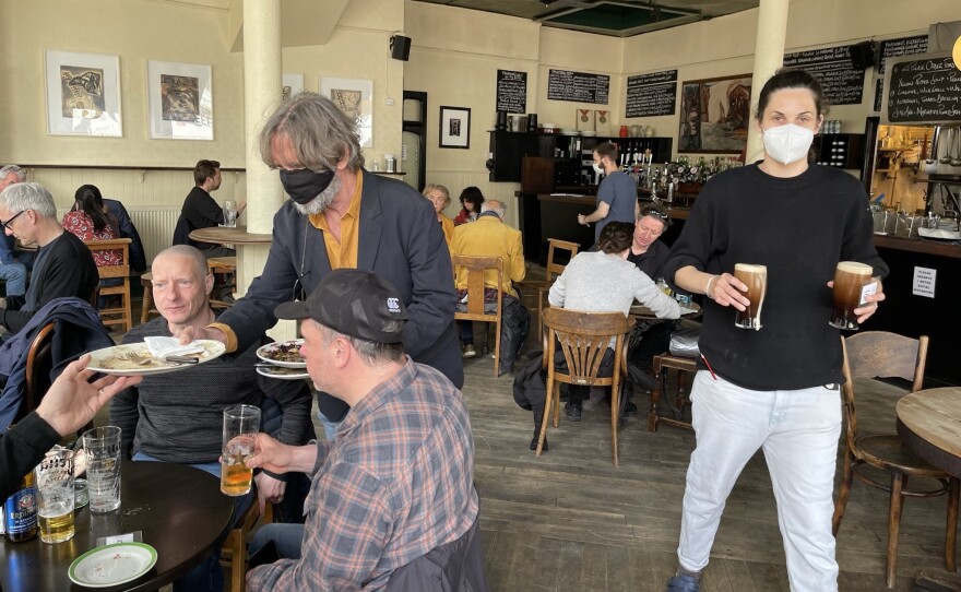 Belben clears plates on the pub's reopening day in May after months of coronavirus lockdown.