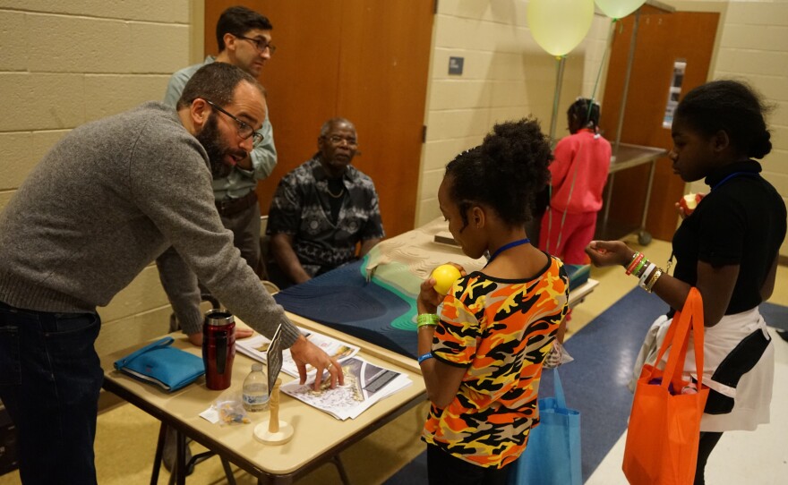 Isaac Hametz, a research landscape architect, explains the coastal resilience project being planned for Fleming Park to a couple of the area's residents.