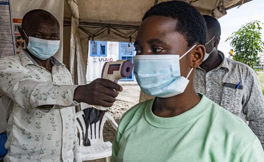 To keep Ebola from spreading in this current outbreak, a border health officer at the Busunga crossing between Uganda and the Democratic Republic of Congo checks a traveler's temperature using a contactless infrared thermometer on May 18.
