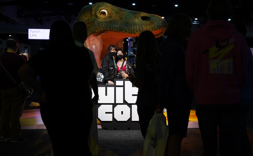 Two TwitchCon attendees pose in front of a TwitchCon display at the entrance to the convention on Oct. 8, 2022.