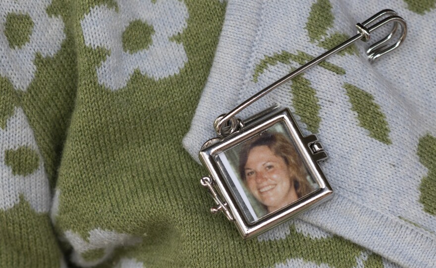 Lauren SinClair wears a pin with a photo of her mother, Susan SinClair, who died by suicide when Lauren was growing up.