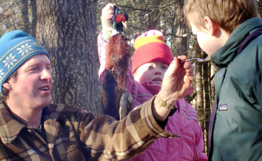 Jeff Potter feeds roadkill pheasant to his kids, Lucy and Henry.