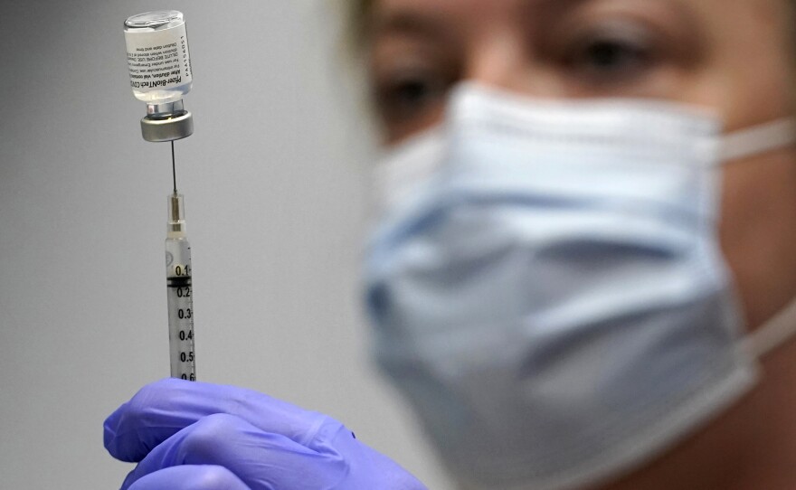 In this March 2, 2021, file photo, pharmacy technician Hollie Maloney loads a syringe with Pfizer's COVID-19 vaccine at the Portland Expo in Portland, Maine. The U.S. gave full approval to Pfizer's COVID-19 vaccine on Monday, Aug. 23, 2021.