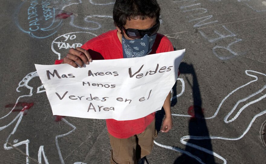 A demonstrator protests the arrival of Mexican President Felipe Calderon in Ciudad Juarez on Feb. 17. He holds a sign reading, "More green areas, less greens in the area" (referring to soldiers). Calderon arrived in the city for the second time in less than a week to meet with local and state authorities to address a security crisis after a group of gunmen attacked a party Jan. 31, killing 15 teens and injuring many others.