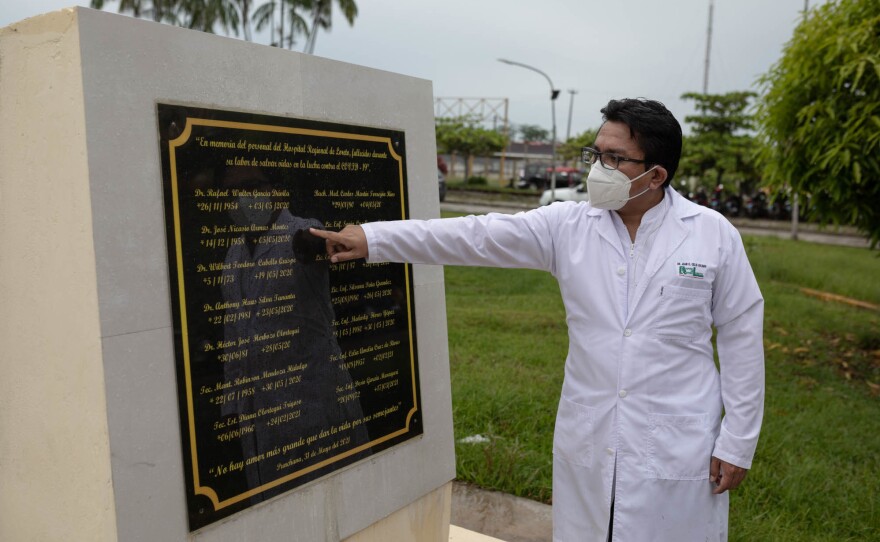 Juan Carlos Celis Salinas, a doctor at the Loreto Regional Hospital, stands by a memorial to the medical staff who died from COVID-19 during the first wave in Iquitos, Peru.