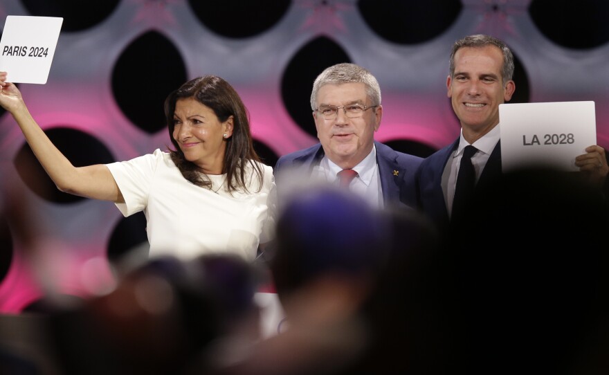 Paris and Los Angeles have been awarded the honor of hosting the 2024 and 2028 Olympic games, respectively. Pictured above: IOC President Thomas Bach (center), Paris Mayor Anne Hidalgo (left) and Los Angeles Mayor Eric Garcetti.