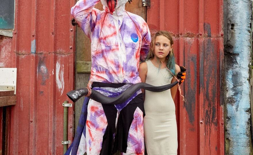 An Okalolie poses with Savanna Green. After quickly taking off his mask to identify himself, the two posed for a picture, like they've done every year since Savanna was a little girl.