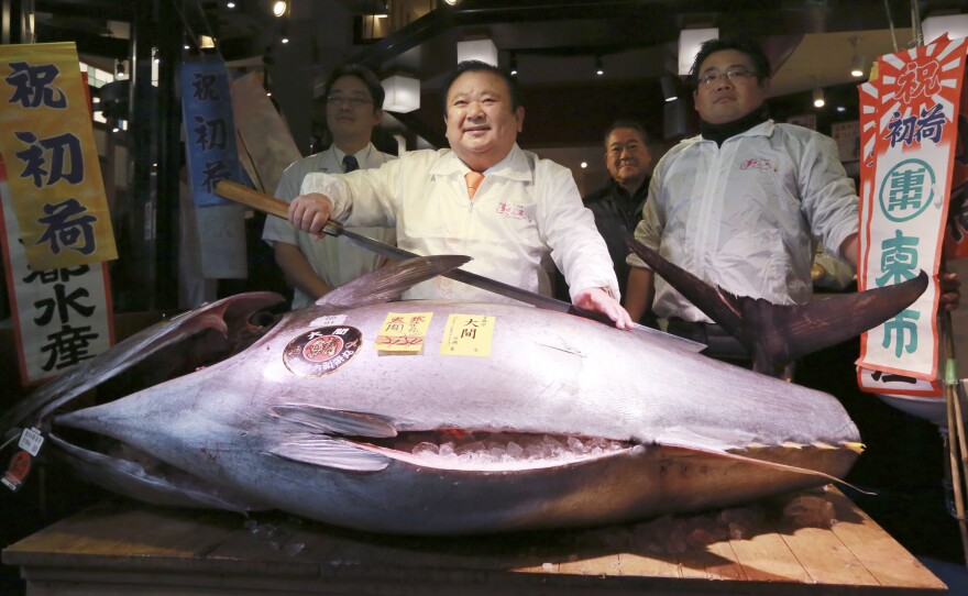Kiyoshi Kimura (center) poses with the Pacific bluefin tuna he won for about $632,000 at the Tsukiji fish market's annual New Year auction. The fish weighs about 466 pounds.
